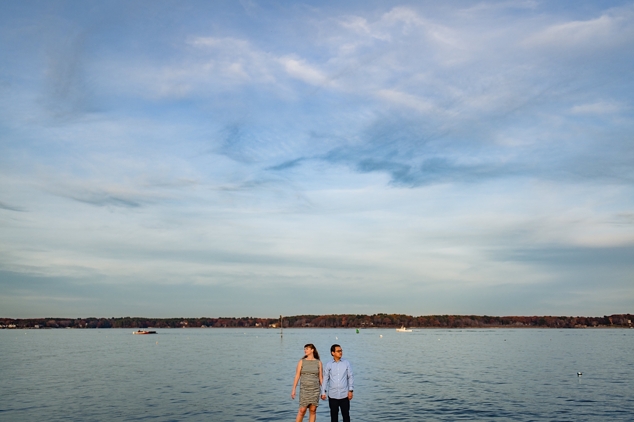 couple holding hands in the very bottom of the image frame, overlooking a river