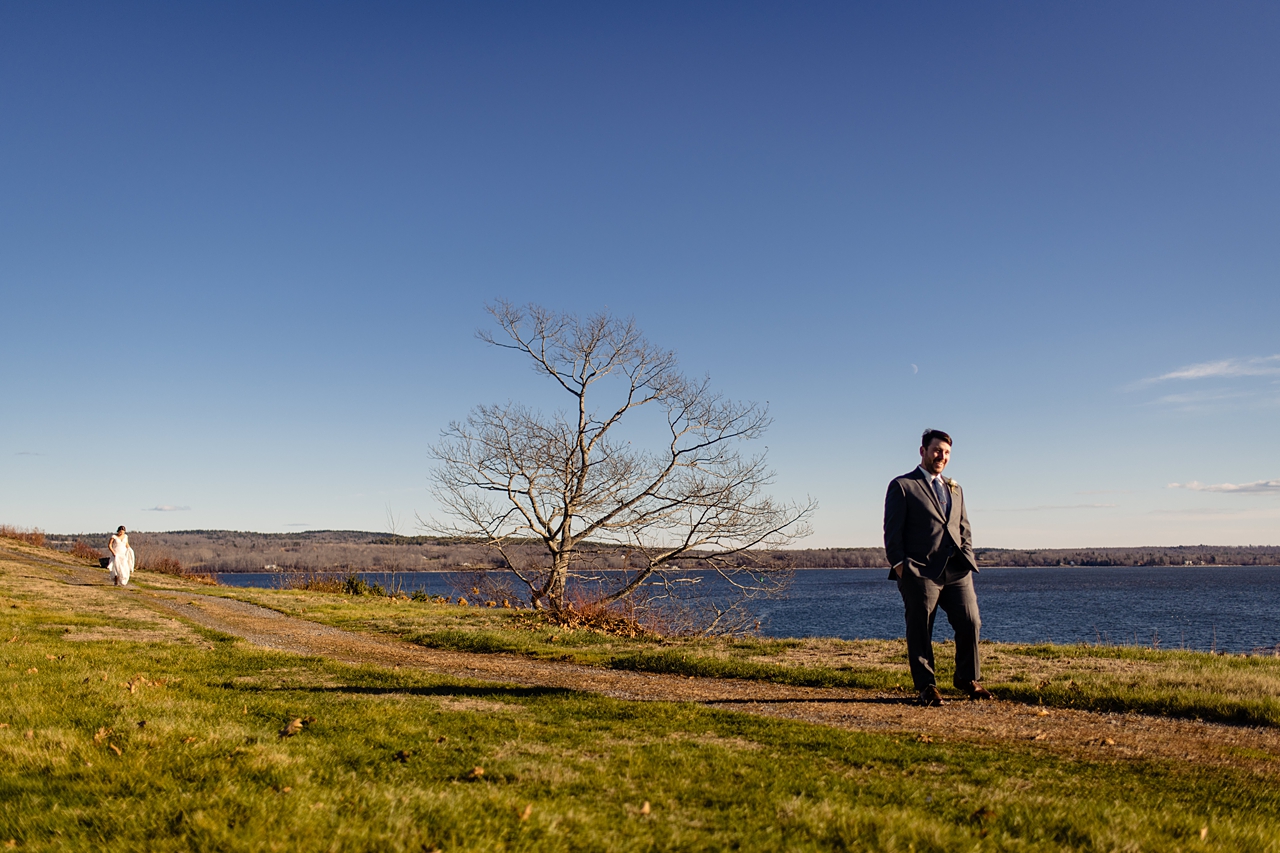 wide angle photo of a bride walking up behind her groom for a first look