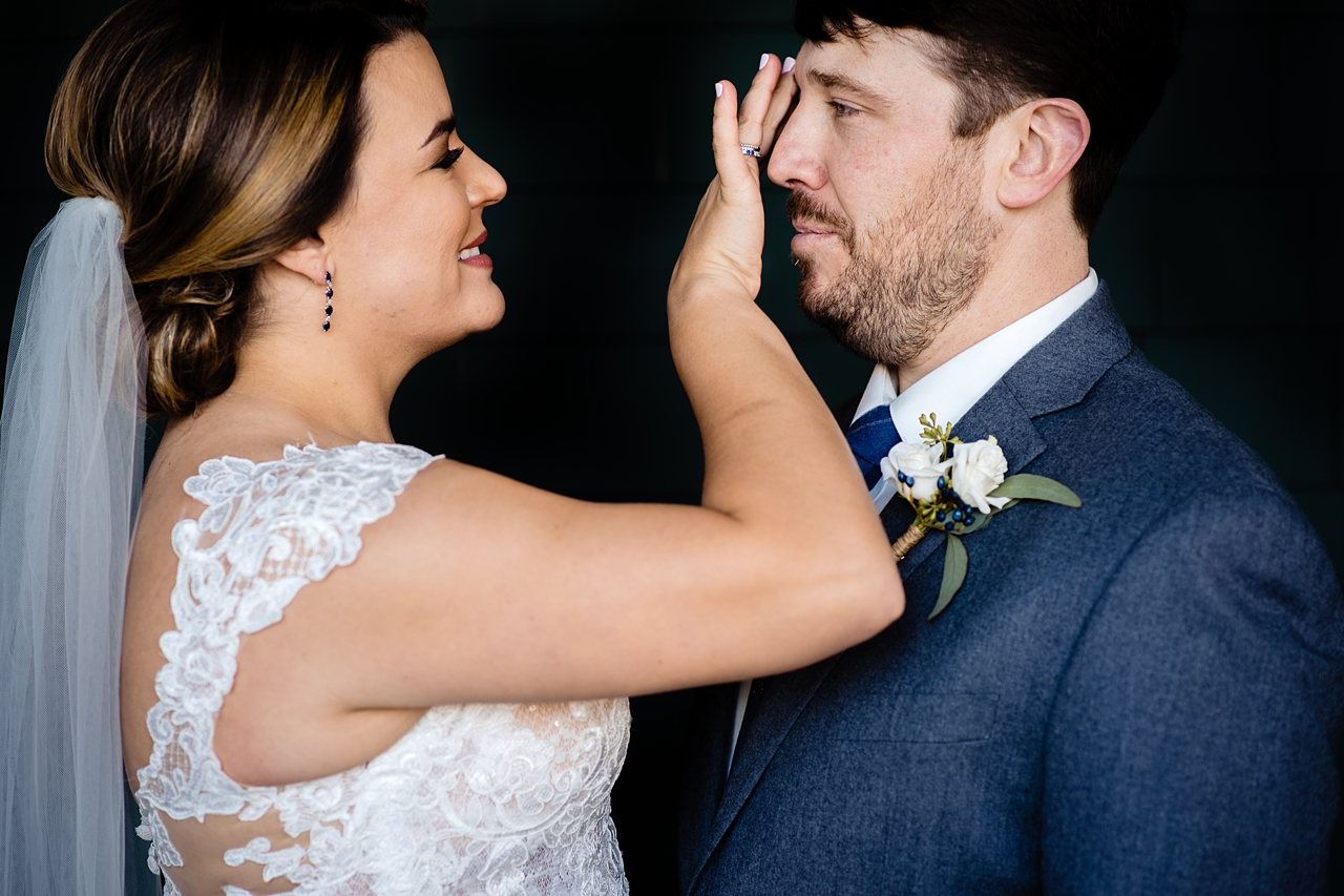 color image of a bride adjusting her grooms hair