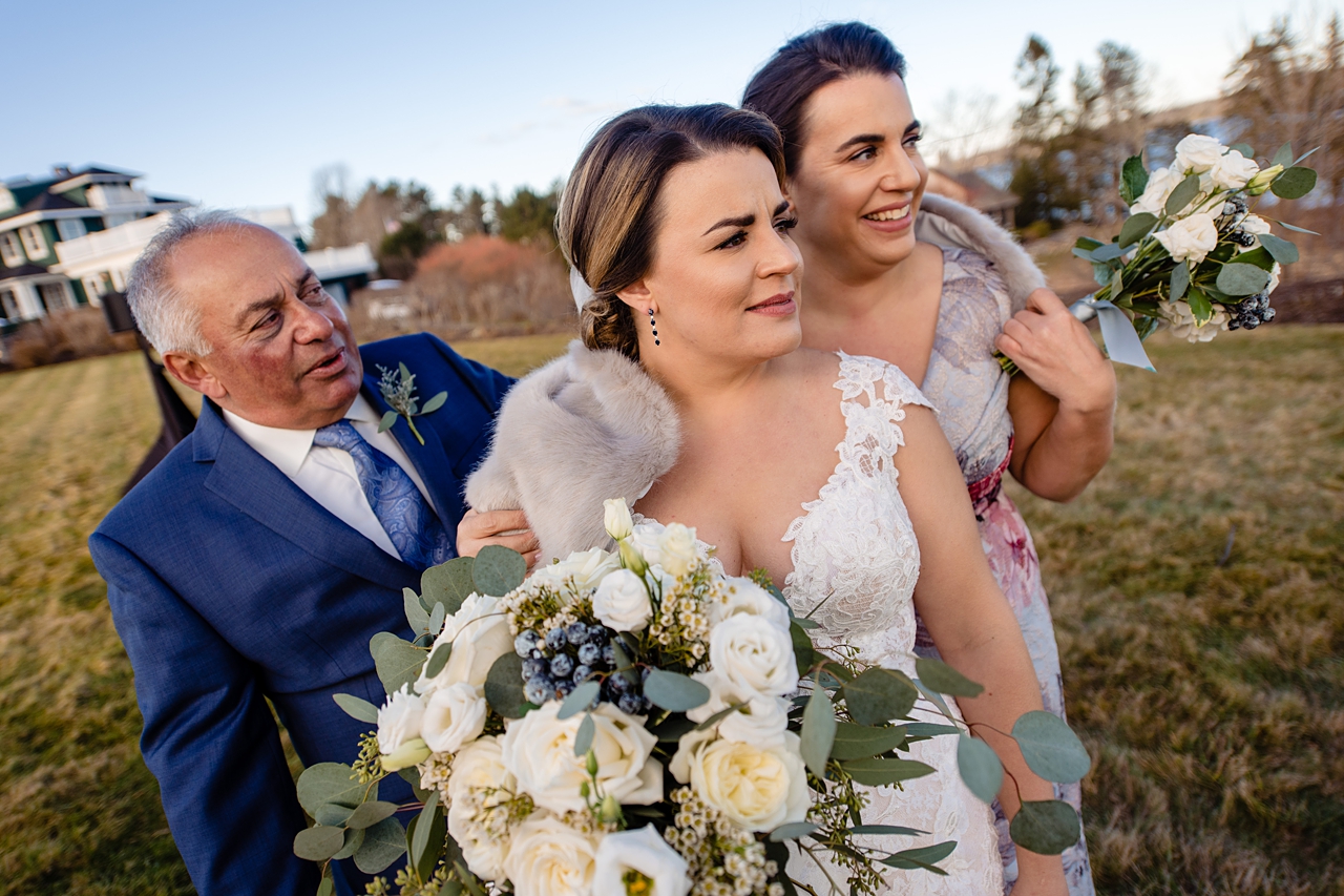 quirky photo of bride, bridesmaid, and father of the bride all looking skeptical about something out of frame