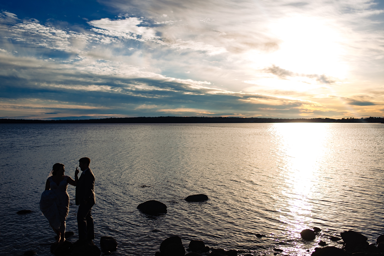 dark photo of couple standing on rocks in the water