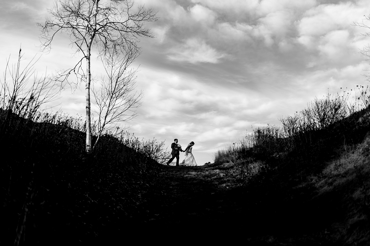 black and white image of couple walking in a valley