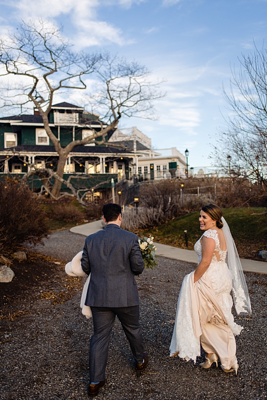 couple walking back towards the venue, with the bride laughing