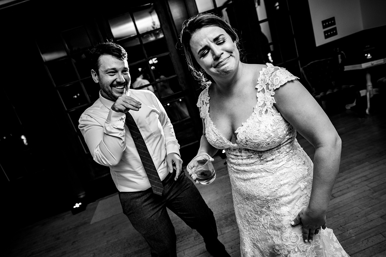 goofy bride and groom on the dance floor in black and white
