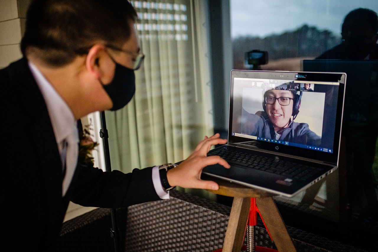 Groom setting up a zoom meeting with wedding guests so they can see the ceremony.