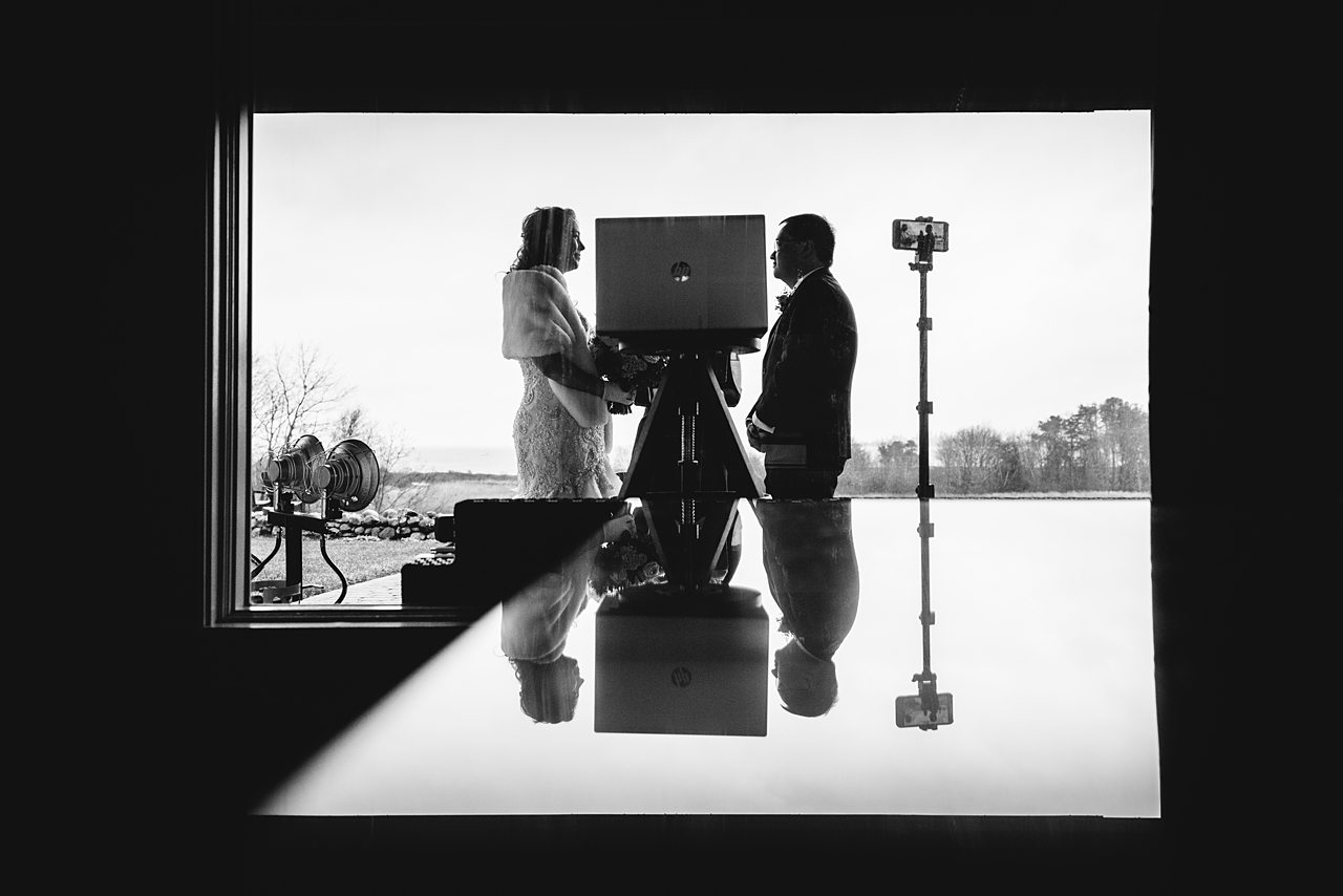 Black and white photo of a reflection of a wedding ceremony.