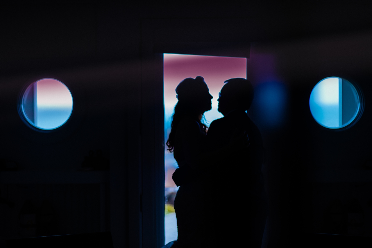 Abstract photo of couple in doorway with blue and purple colors.